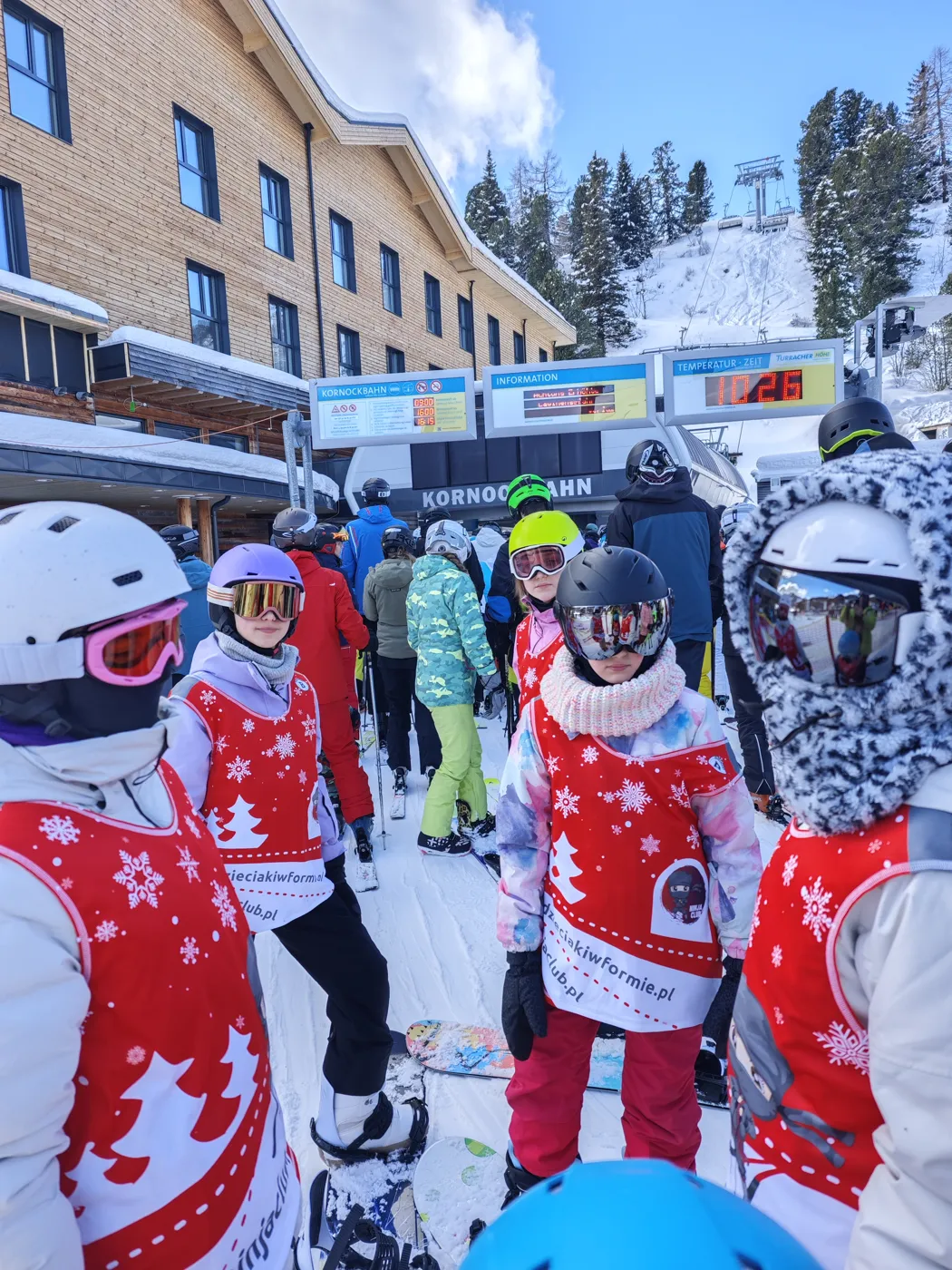 Grupa dzieci w plastronach Ninja Club przy wyciągu narciarskim