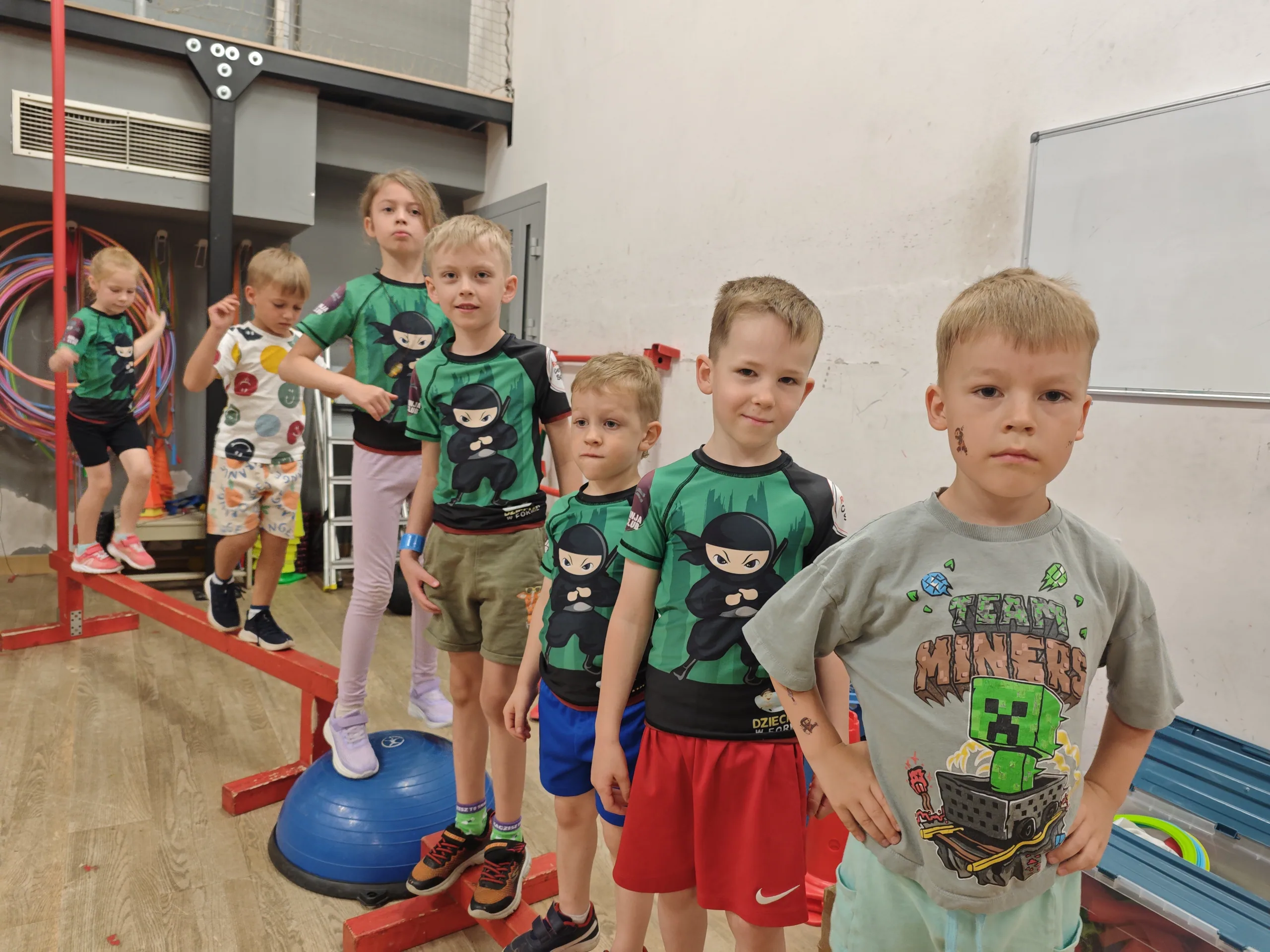 Grupa dzieci w koszulkach Ninja Club przed treningiem