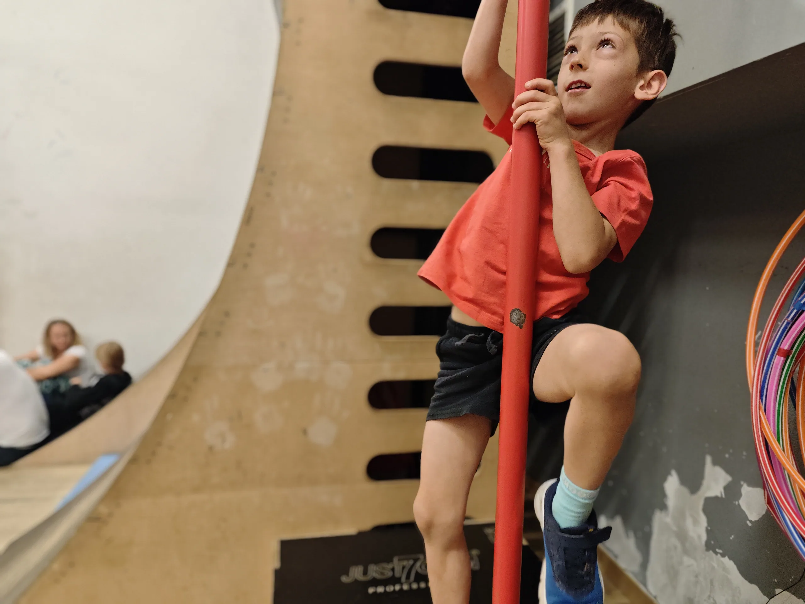 Chłopiec wspinający się po rurze na ściance warped wall